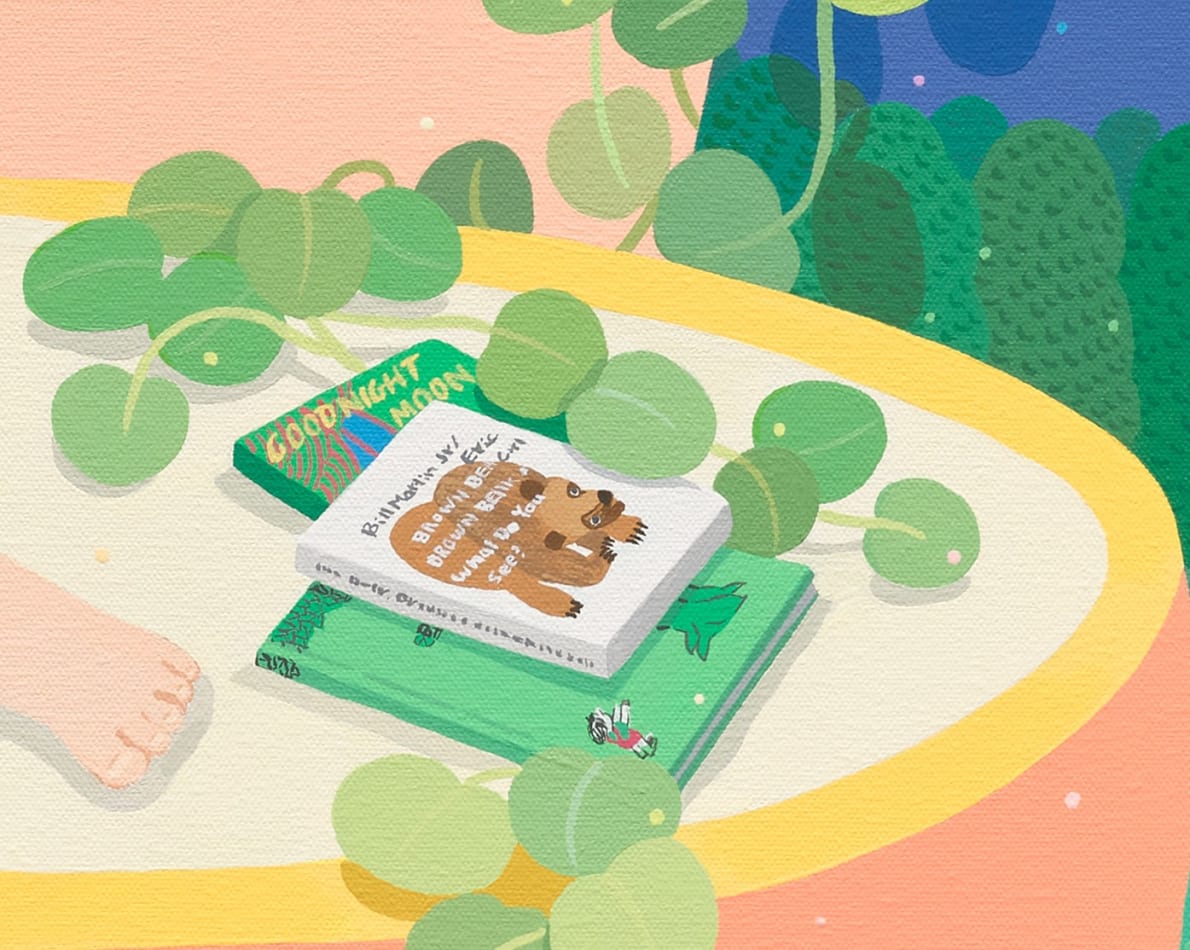 detail image of a phile of books resting on eachother with a green plant next to them