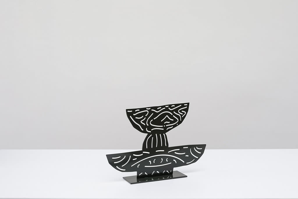 Metal sculpture of two black plates with cutout design