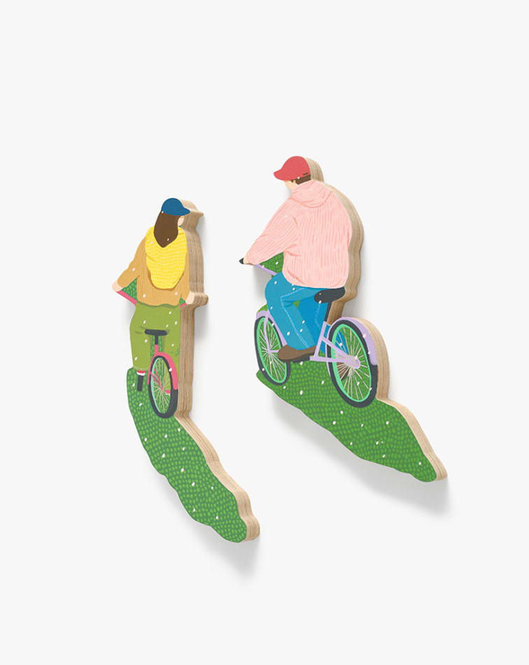 sculptures of two people riding bikes