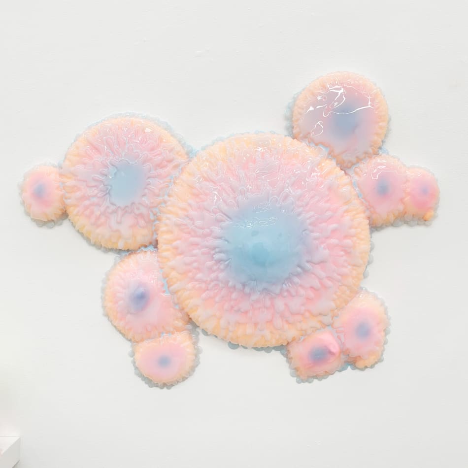 Sculpture with multiple circular objects with a pink to purple gradient by Dan Lam.