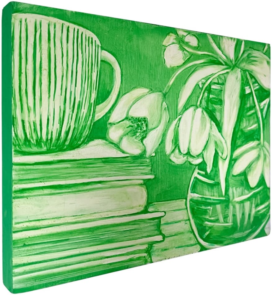side view of Grace Tobin painting in green tones. Flowers in vase and stack of books with coffee mug on top