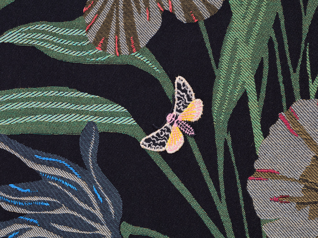 Detail of Oona Brangam-Snell hand-woven embroidery of large frog, flowers and fairy like women