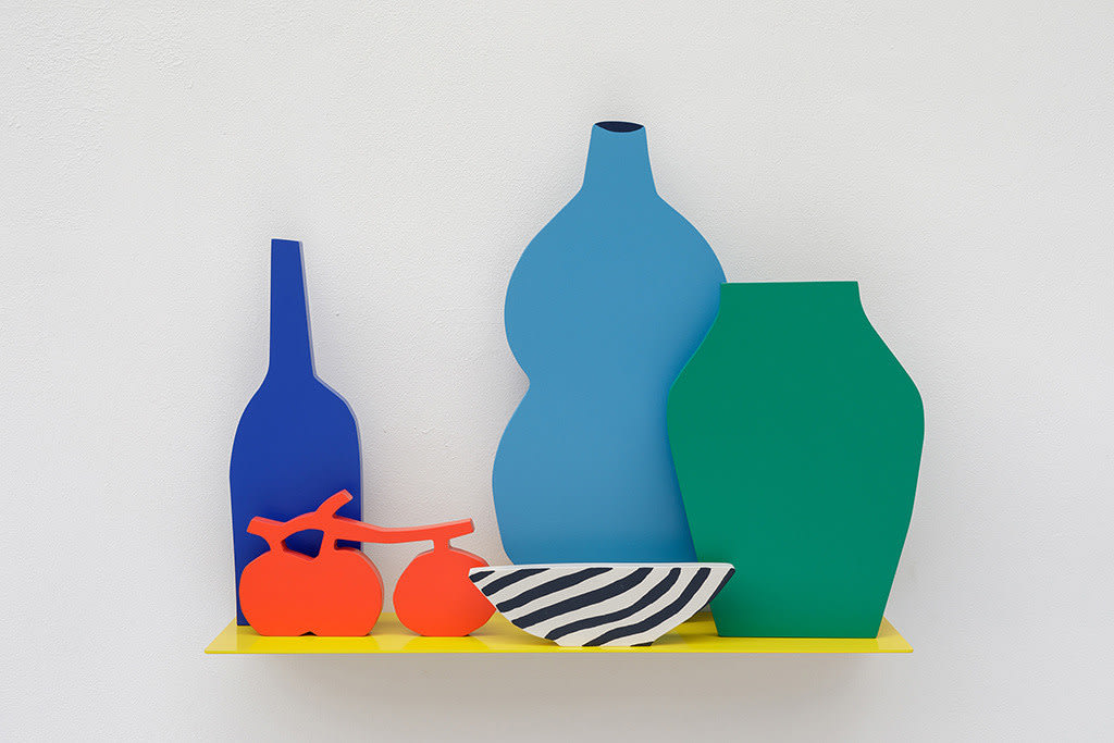 Sculpture of a yellow shelf with the silhouettes of a dark blue wine bottle, a light blue vase, a green vase, a striped white and black bowl and three tomatoes on the vine on a yellow shelf.