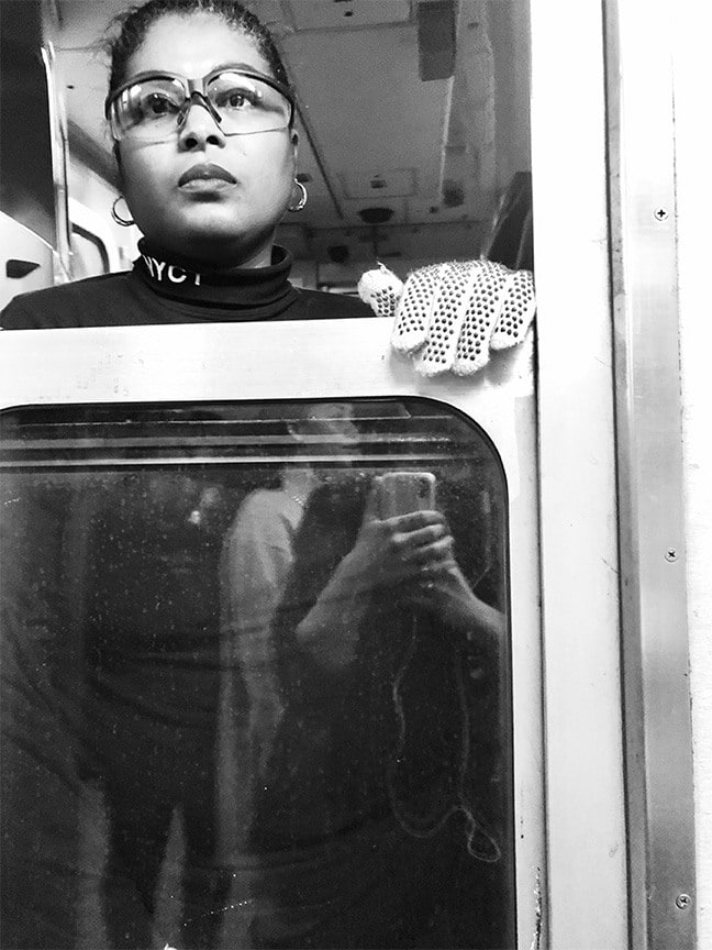 black and white photo of a subway train conductor looking out the window