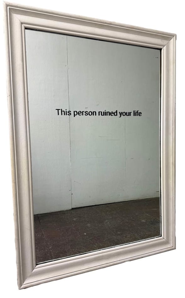 Mirror in a white frame with the words 