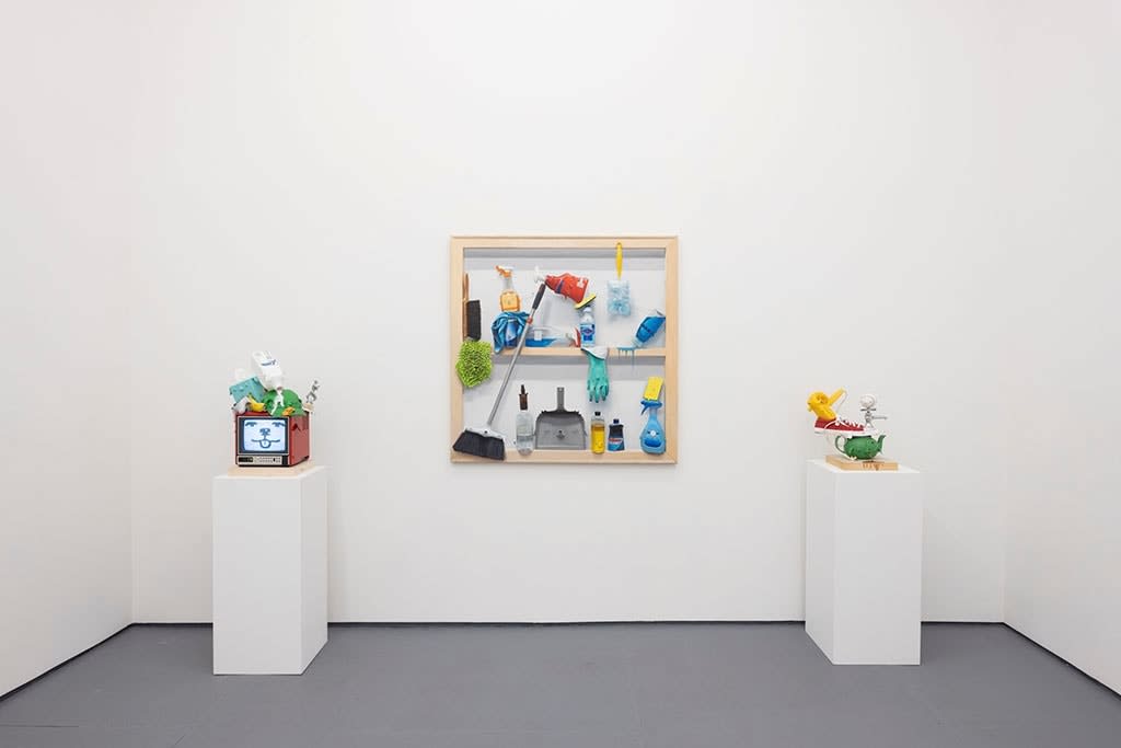 white wall with a painting in the middle and sculptures on either side