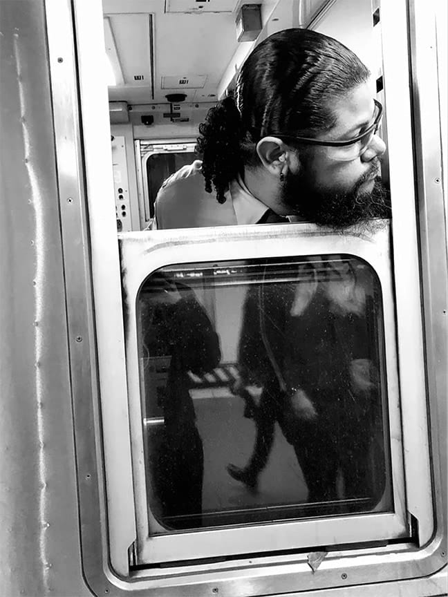 black and white photo of subway train conductor looking out the window