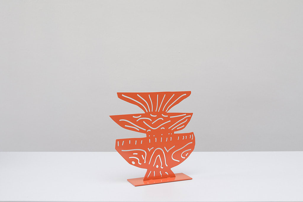 Metal sculpture of three plates stacked on top of each other with a design