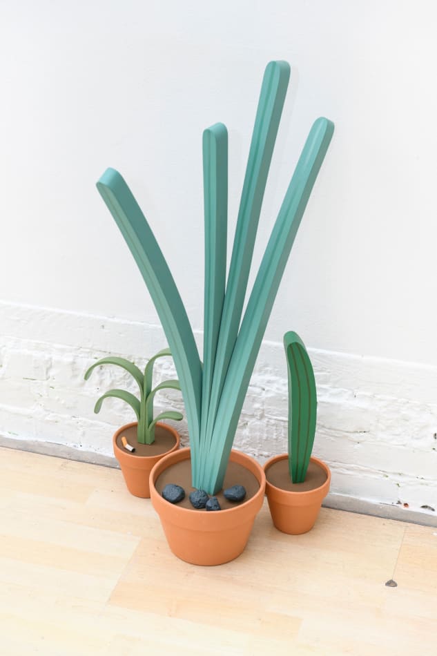 Jeff Canham wooden plant sculptures in terra cotta pots- in a cluster on the floor