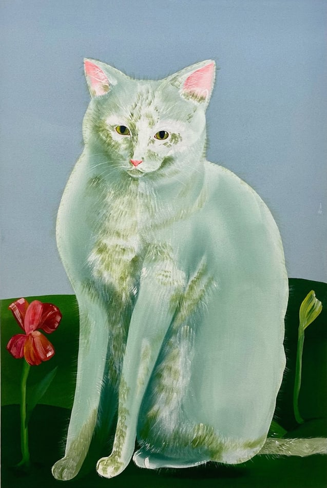 seated white cat next to a red flower