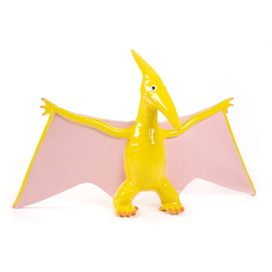 ceramic sculpture of a yellow Pterosaur with pink inner wings