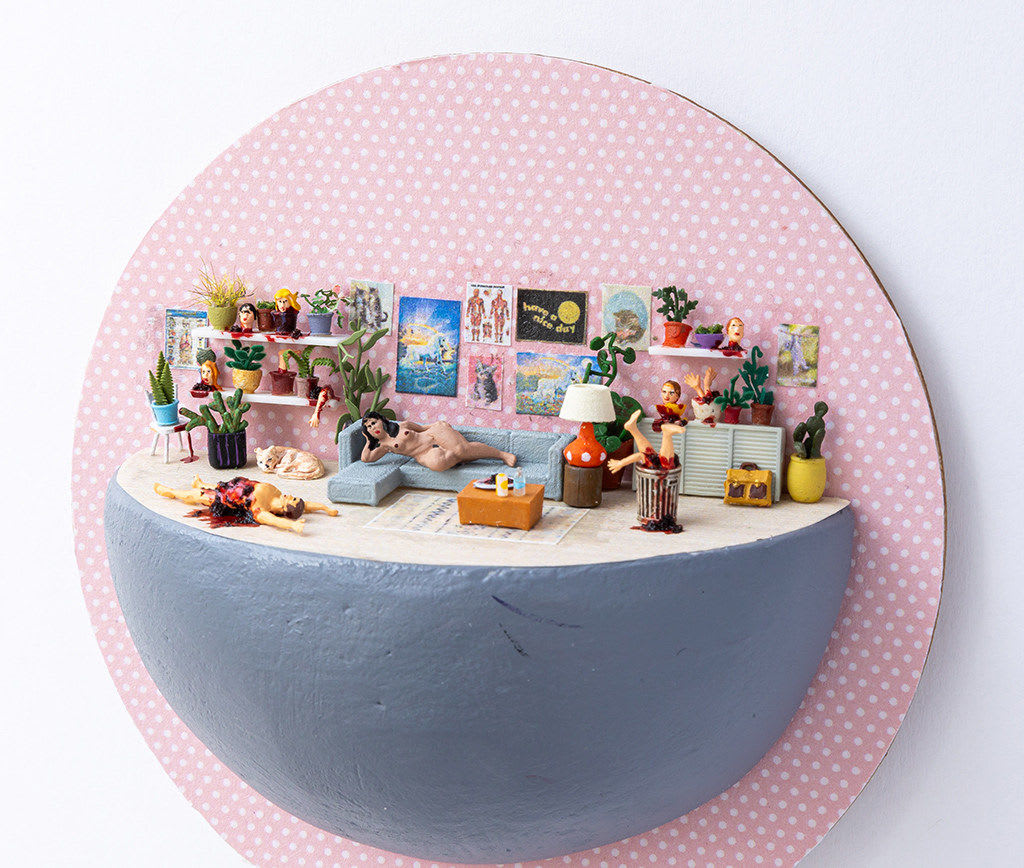 miniature diorama by Abigail Goldman of a woman laying on the couch next to a bloody man on the floor and severed body parts