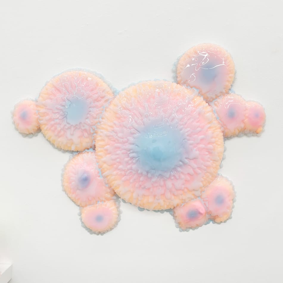 Sculpture with multiple circular objects with a pink to purple gradient by Dan Lam.