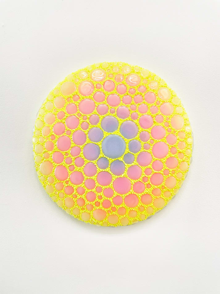 Circular sculpture by Dan Lam with pink and purple circles and tiny bright yellow spikes