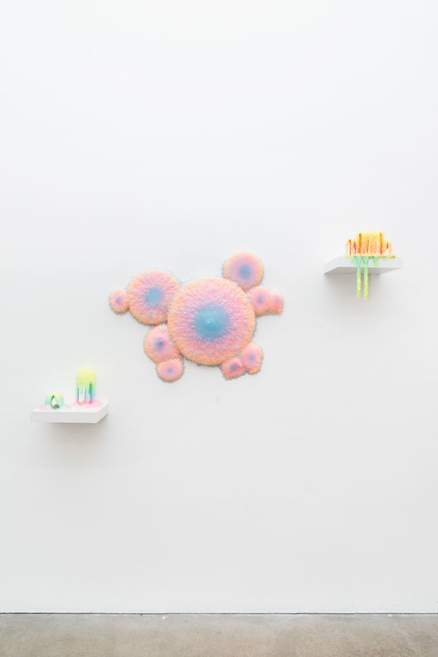 Installation shot of a sculpture with multiple circular objects with a pink to purple gradient by Dan Lam.