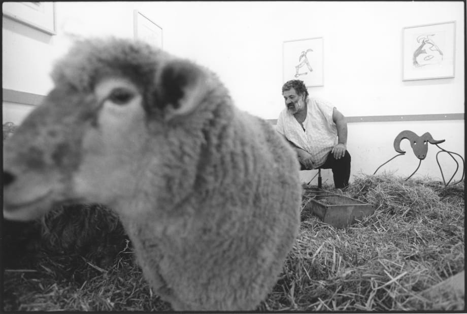 an photograph by John Riddy of the artist Menashe Kadishman tending sheep during his exhibition at Annely Juda Fine Art, London, 1992