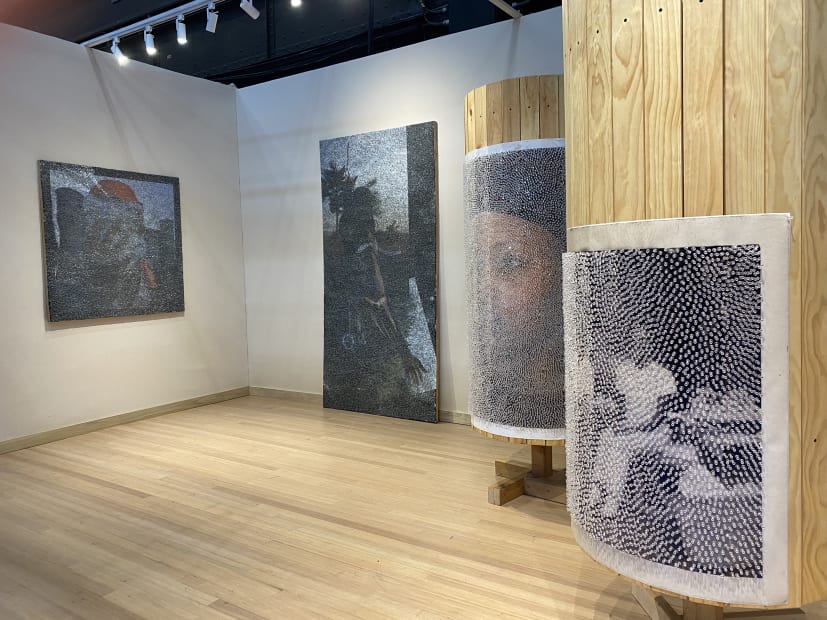 Installation of four Wilmer Wilson IV pieces, two panels covered in staples and two wooden cylinders with photographs and pushpins
