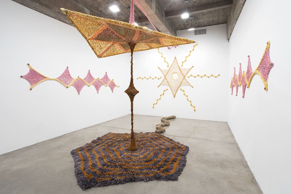 Ernesto Neto installation with crochet in middle of room and crochet on the wall