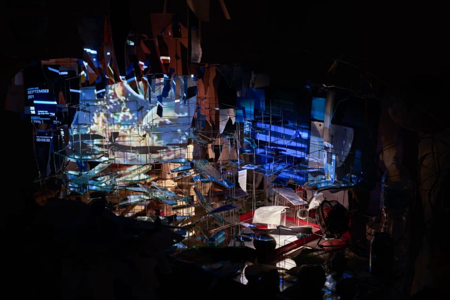 Sarah Sze installation in dark room of video projections on a desk