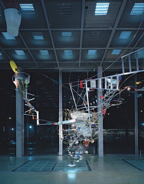 Image of Sarah Sze installation of ladders and other objects circling from ceiling to floor