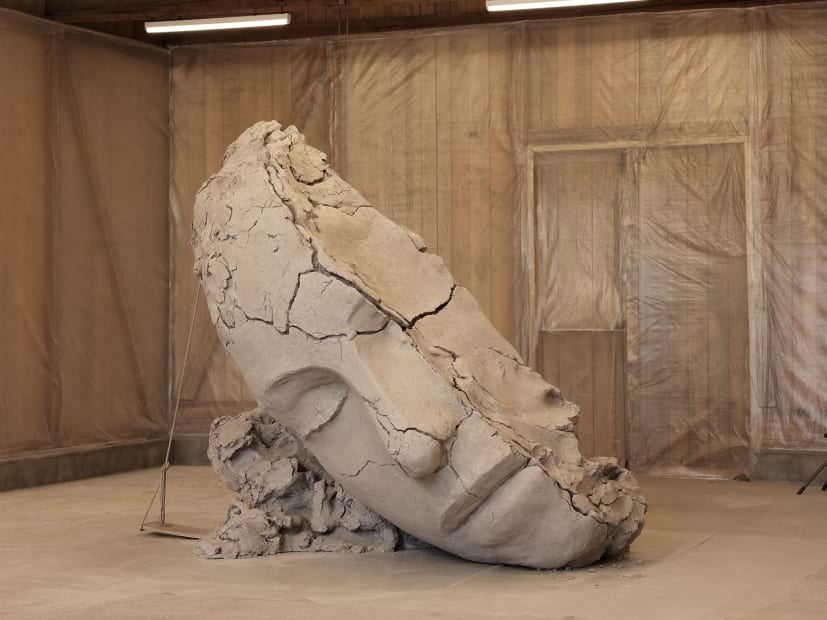 image of Mark Manders installation inside of barn, dry clay head sculpture