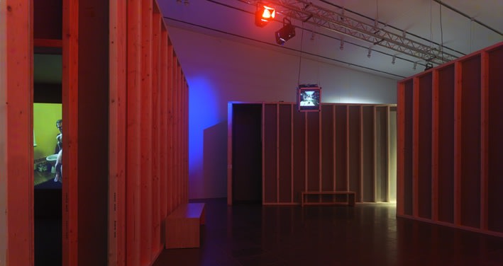 image of Gillian Wearing video rooms in darkened room