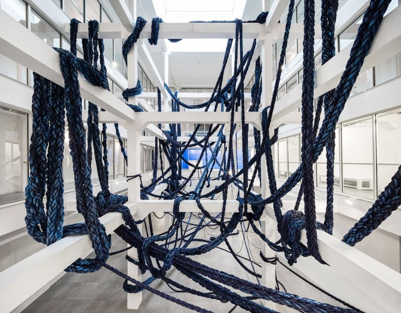 image of braided blue rope hanging from beams and architecture