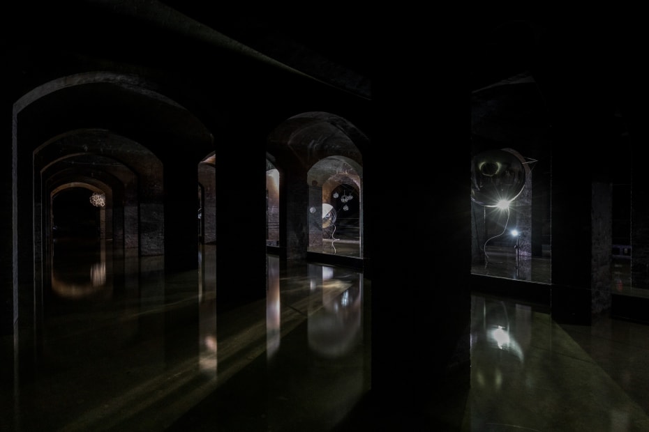 image of Saraceno sculptures hanging in dark room over water