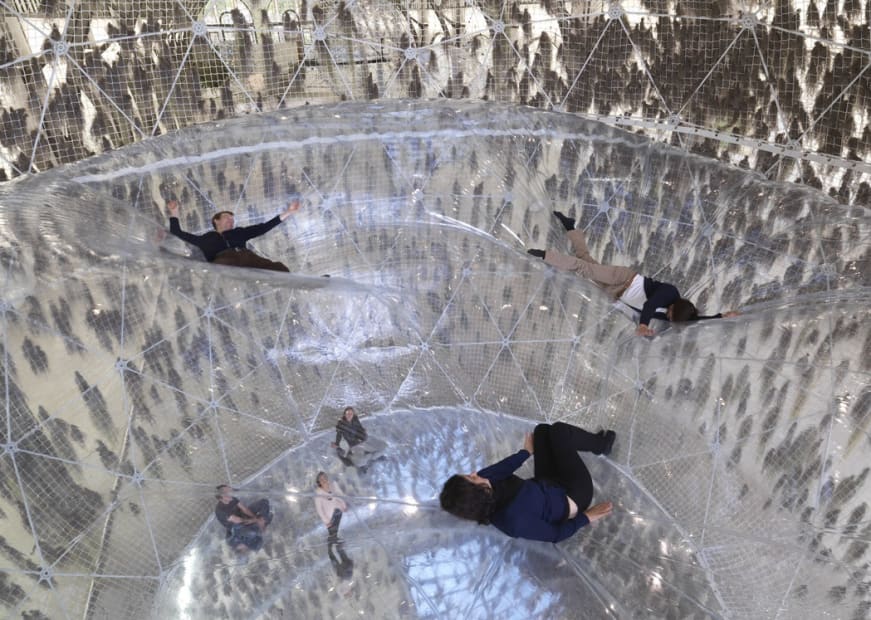 image of people laying on clear plastic baloon