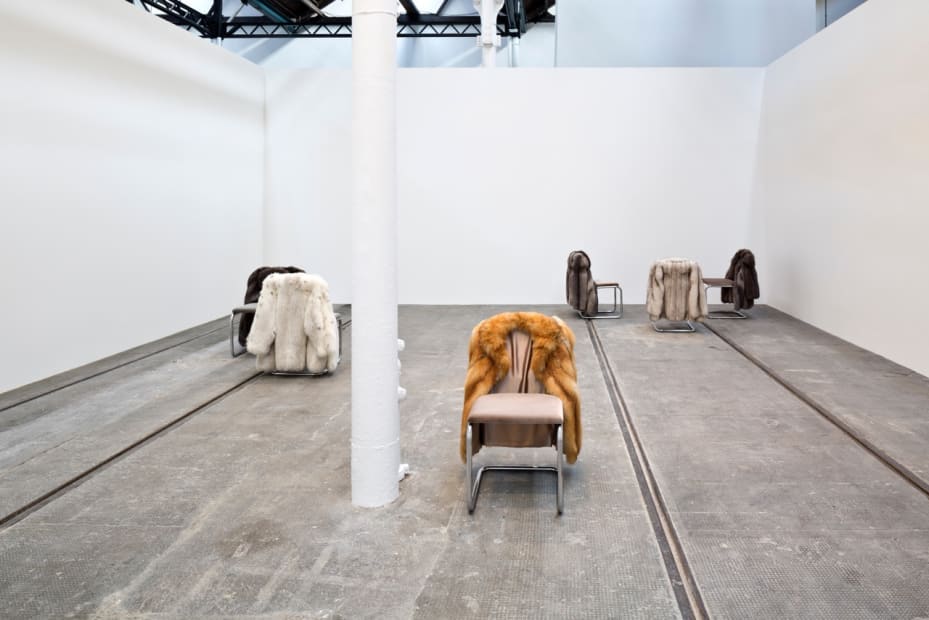 image of chairs with fur coats hanging off of them