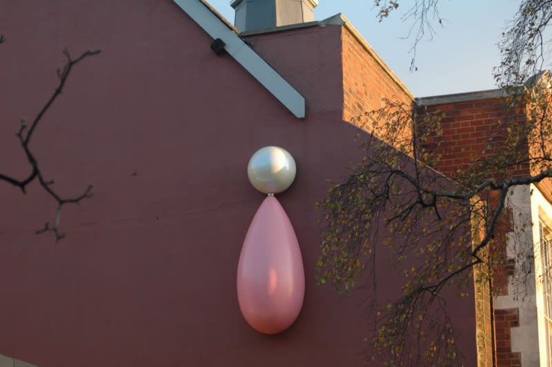 image of a large earring sculpture on building