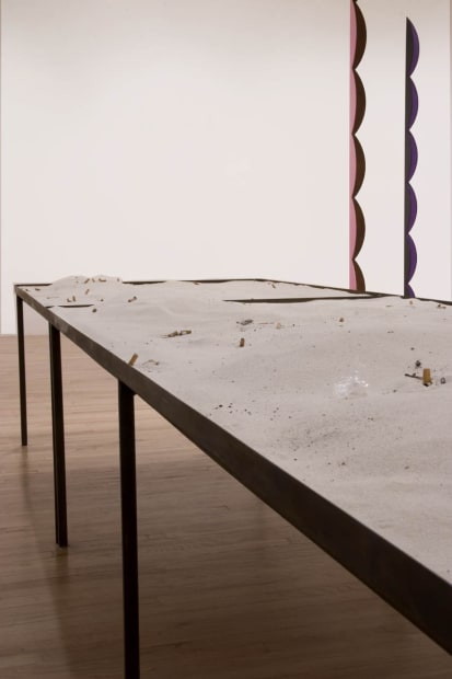 image of Nicole Wermers circular sculpture with table of sand and cigarettes