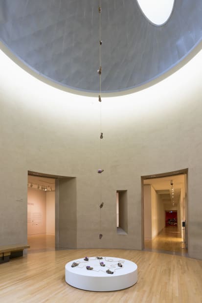 sculpture trailing from the ceiling to ground within an atmospheric room