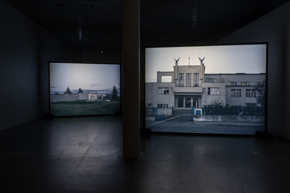 Susan Philipsz's film still image, two channel projection of concrete building facades in dark room
