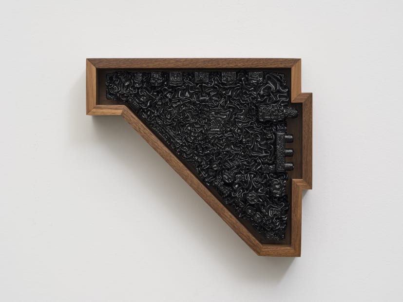 black and wooden sculpture on white wall