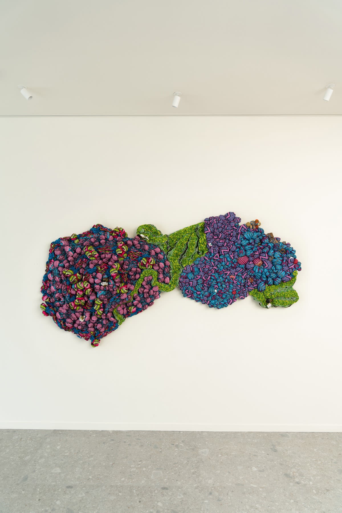 Journey to the Center In Journey to the Center, Samuel Nnorom delves into the theme of migration, contemplating the human condition interwoven with the resilience necessary for survival. Through a magnificent palette of cold colors, the mural sculpture aspires to depict the challenging journey — both physically and emotionally — undertaken by individuals in the pursuit of hope within the Unknown. Transforming his "social fabric" into a vibrant landscape, the artist skillfully captures the collective movement of people navigating the obstacles presented by migration, all in search of new opportunities.