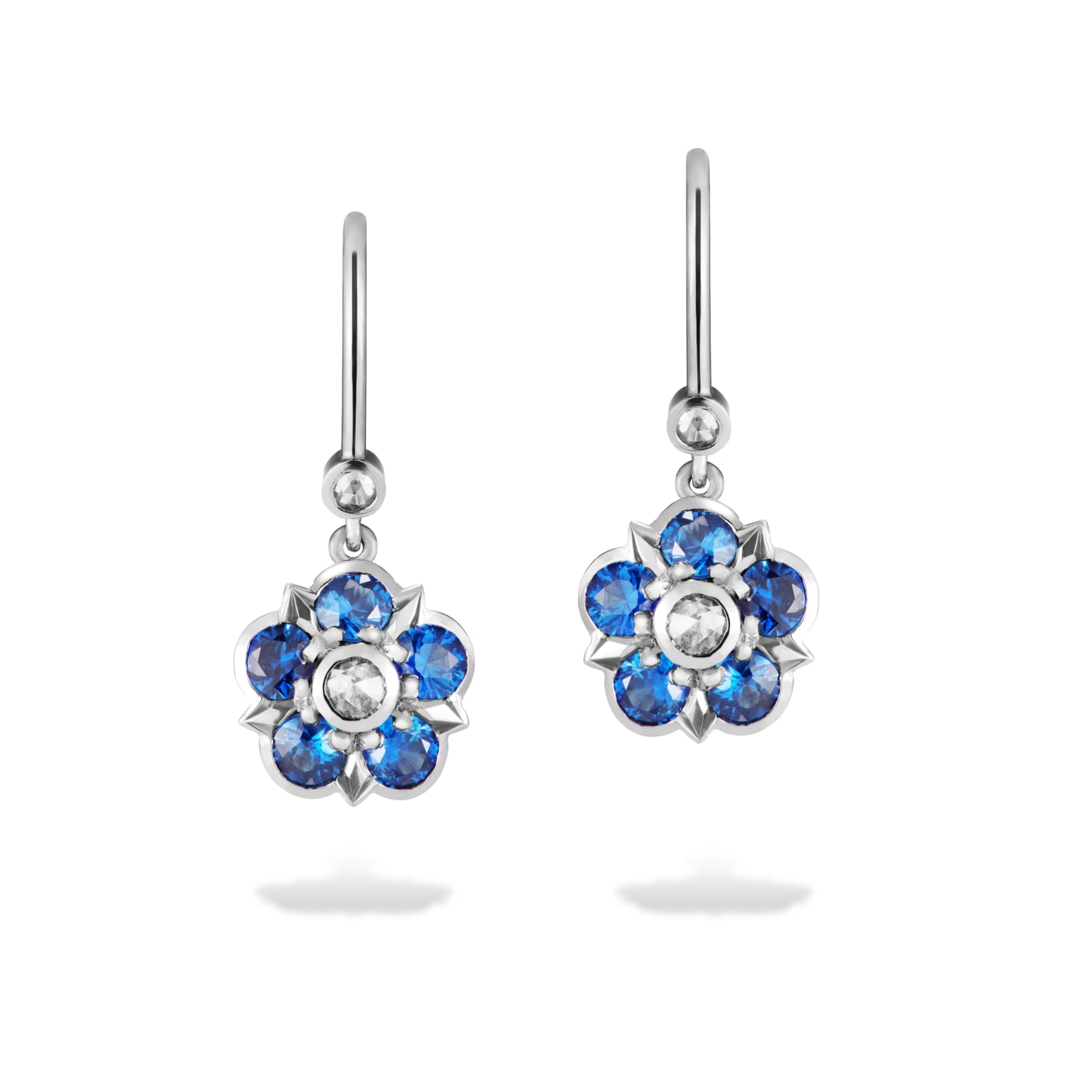 Sapphire and diamond earrings in a floral design, set in platinum on a white background