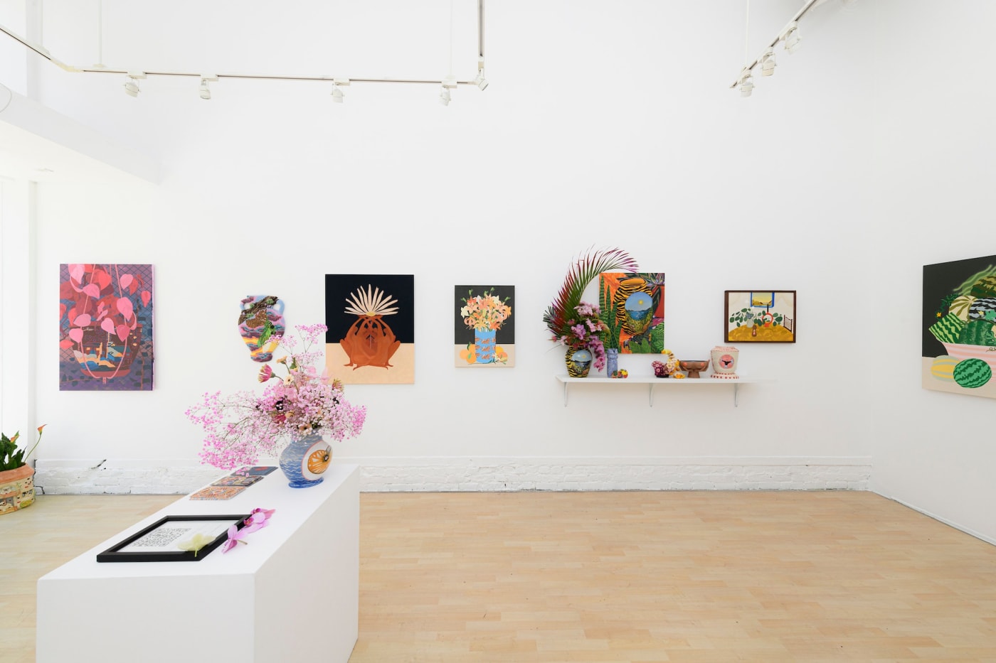 Vessel installation view - flower bouquet on table in foreground paintings of colorful forms in background