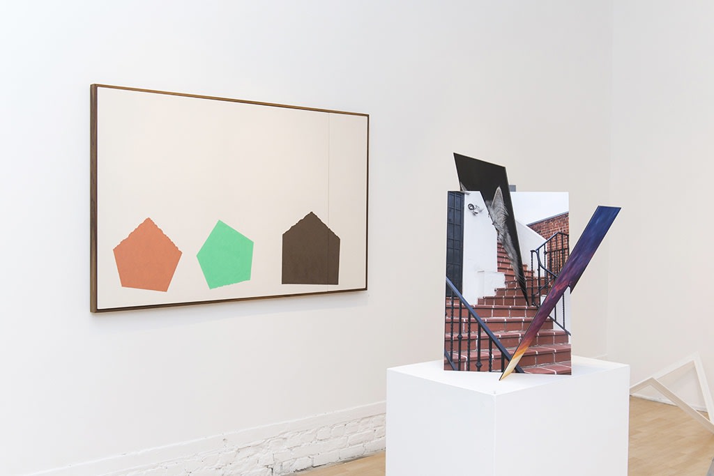 Exhibition installation view featuring abstracted sculptural work in foreground, paintings in background