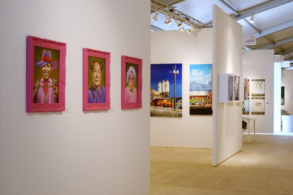 Art fair exhibition featuring pink framed portraits by Scott Scheidly