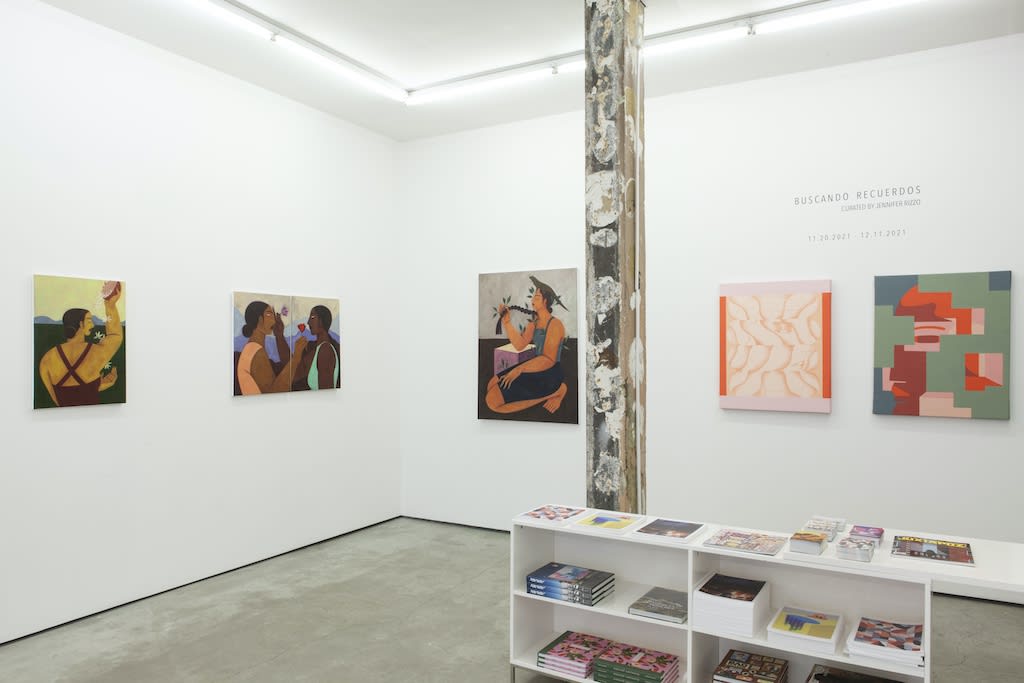 Installation view of "Buscando Recuerdos" group exhibition,  gallery desk in foreground and various paintings on wall in background