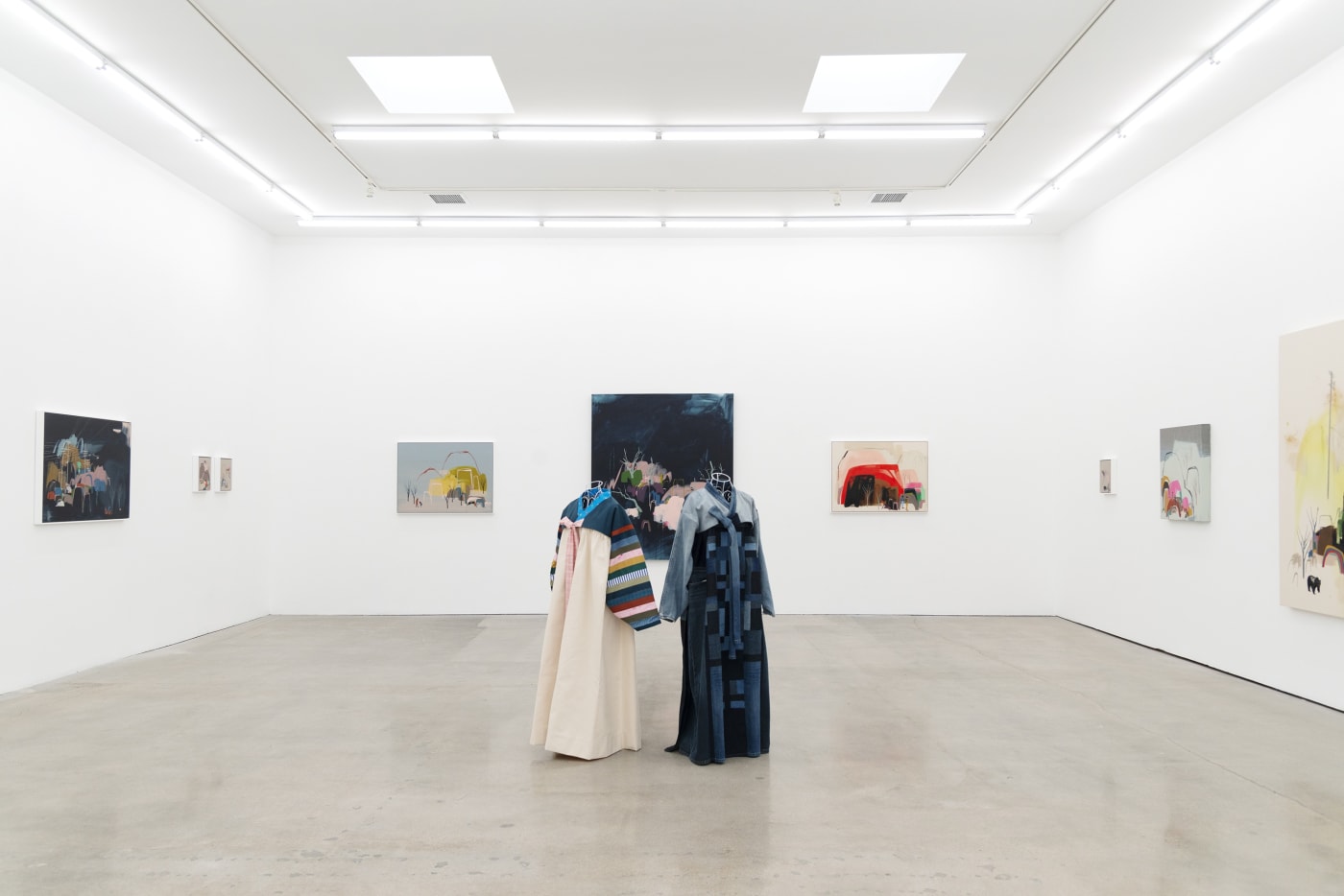 Seonna Hong installation view of solo exhibition Late Bloomer, two mannequins adorned with hanbok in center, large paintings in background on walls
