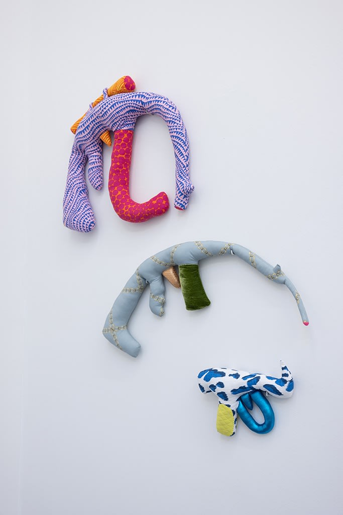 Cloth guns hung on a wall made by Natalie Baxter