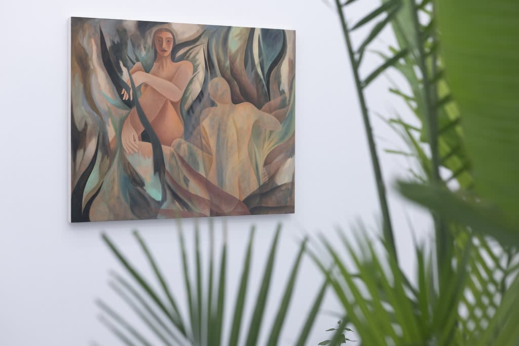 photograph of plant leaves in the foreground and figurative paintings in the background