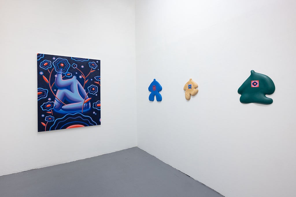 installation picture of Jocelyn Tsaih's "The Garden is Open" of colorful paintings and wooden figures on white walls