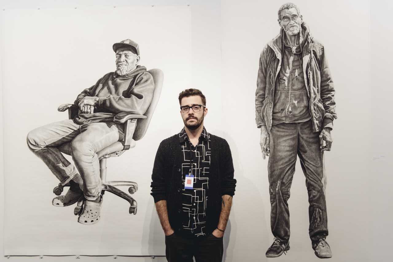 Portrait of artist Joel Daniel Phillips with his work