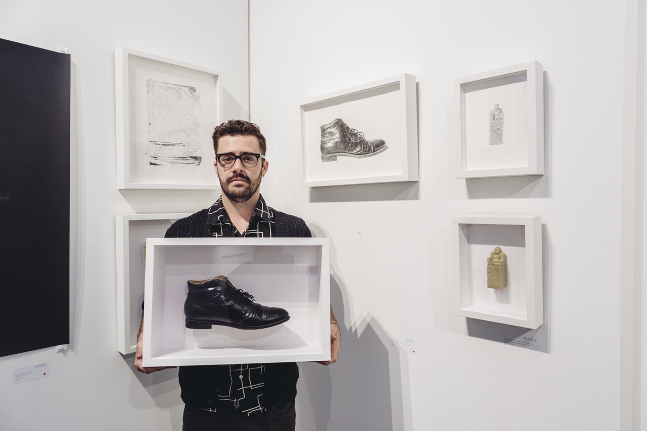Portrait of artist Joel Daniel Phillips with his work