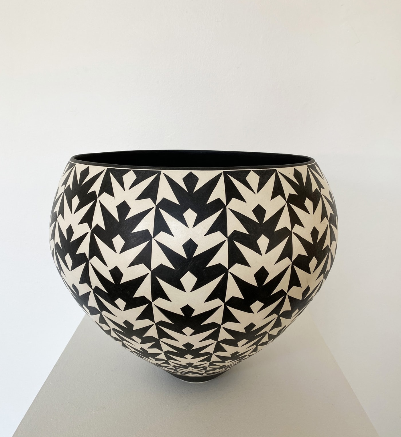 Tydd Pottery wide, round ceramic black and white vessel with a repetitive frog pattern formed vertically across it.