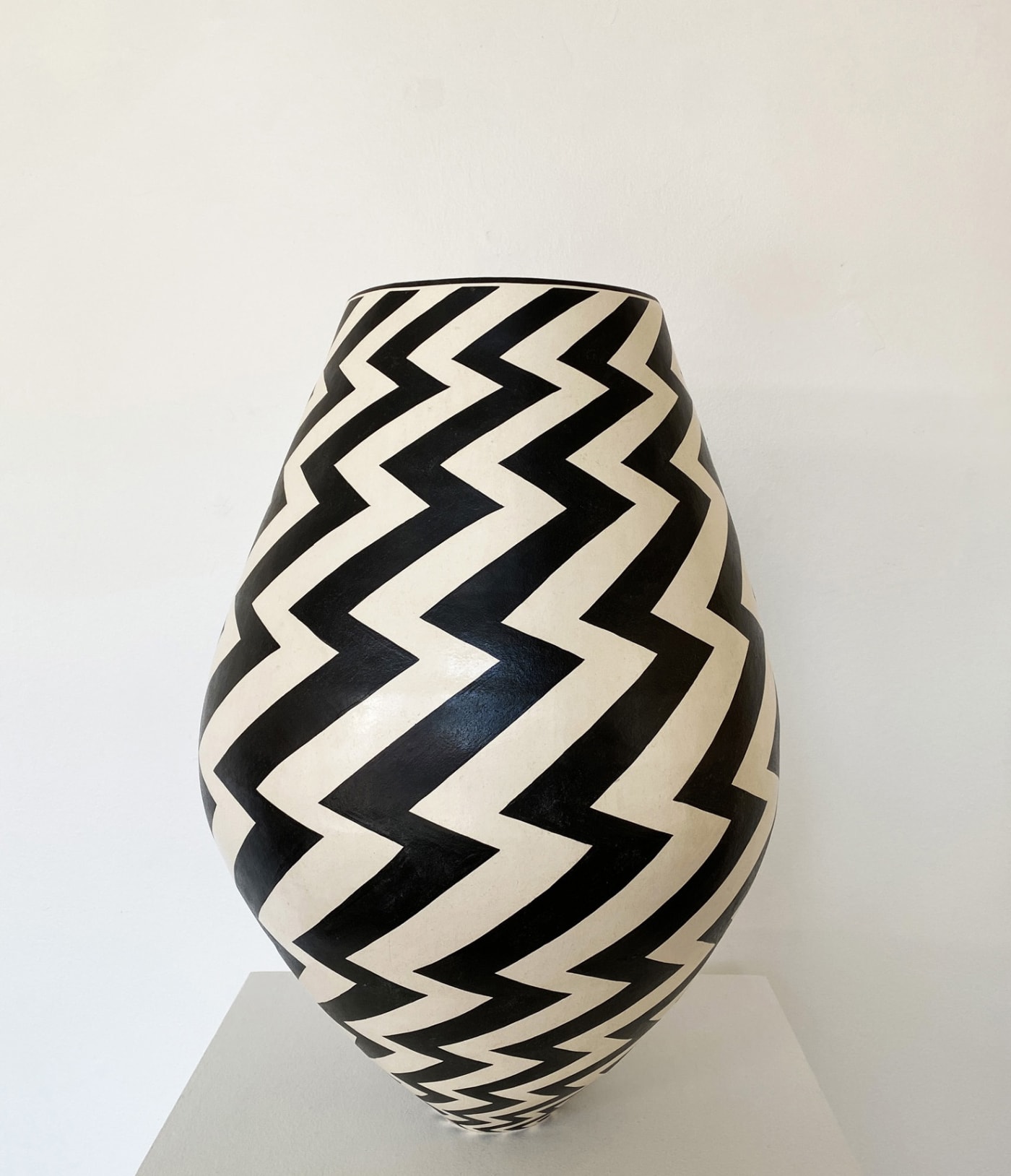 Tydd Pottery wide, egg shaped ceramic black and white vessel with a vertical zig zag pattern.