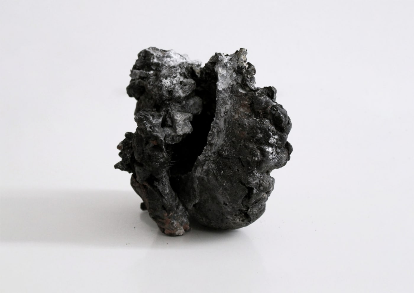 Un sogno restituito dal mare, 2025, Silver flakes, silver pigment, charcoal black, liquid bitumen and Jesmonite AC730